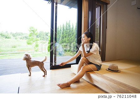 犬とコテージでくつろぐ女性 76211048