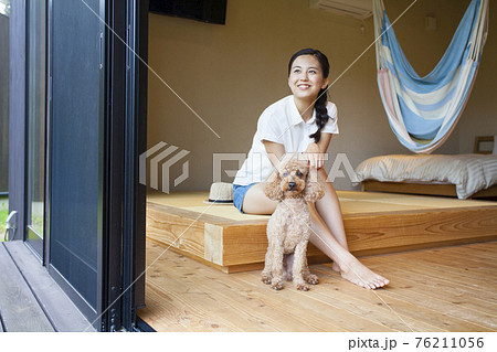 犬とコテージでくつろぐ女性 76211056