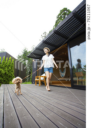 コテージのウッドデッキで犬と遊ぶ女性 コテージのウッドデッキで犬と遊ぶ女性 76211067
