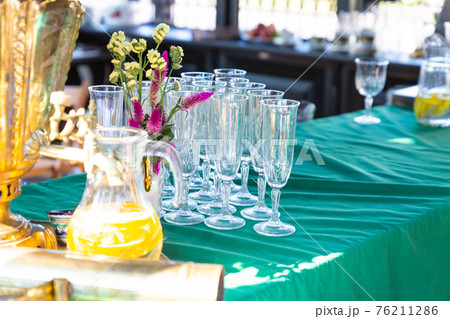 transparent glass goblets next to a carafe of orange juice summer holiday transparent glass goblets next to a carafe of orange juice summer holiday 76211286