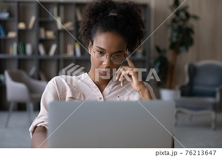 Pensive biracial woman work on laptop thinking 76213647