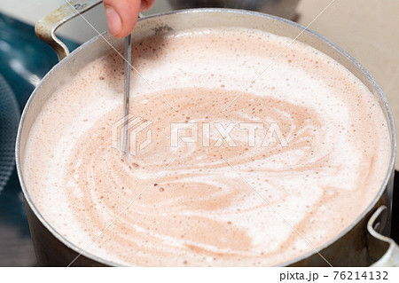 Mixing chocolate and milk for making souffle. 76214132