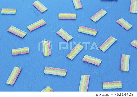 Colorful gummy candy pattern on an blue background. Soft gums look from above. Colorful gummy candy pattern on an blue background. Soft gums look from above. 76214428