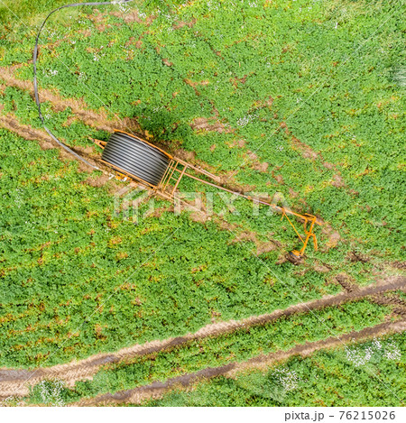 Vertical aerial view with the drone of a huge hose reel Vertical aerial view with the drone of a huge hose reel 76215026