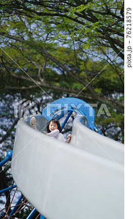 Asian chinese child coming down on slide playing sliding Asian chinese child coming down on slide playing sliding 76218579