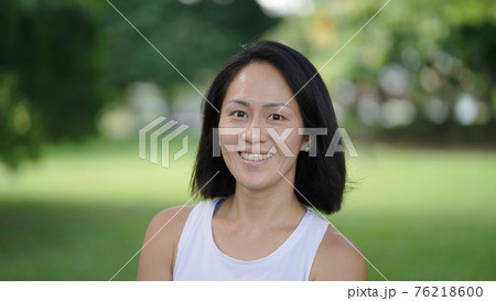 Asian chinese woman smiling sweetly outdoors garden active sporty 76218600