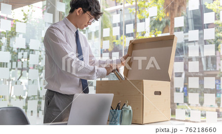Put the work equipment in the office in a large brown box, Businessmen are keeping work documents and personal belongings due to resignation or being fired, termination of employment. 76218660