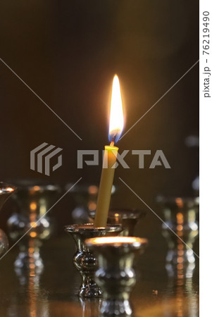 Church candle burning in the temple. 76219490