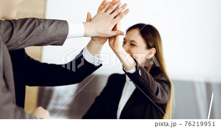 Unknown business people group joining hands in modern office. Businessmen and women making circle with their hands as a team, close-up Unknown business people group joining hands in modern office. Businessmen and women making circle with their hands as a team, close-up 76219951