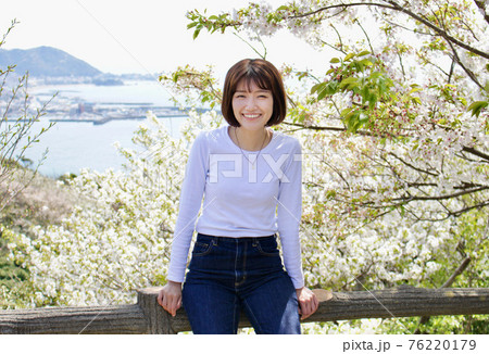 桜と海を背景に笑顔の女性 2  76220179