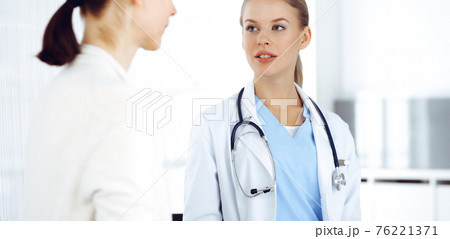 Woman - doctor consults her female patient while using clipboard and medication history record. Medicine concept Woman - doctor consults her female patient while using clipboard and medication history record. Medicine concept 76221371