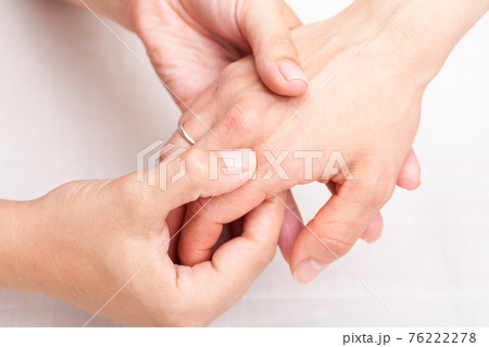 Woman receiving osteopathic treatment of her finger 76222278