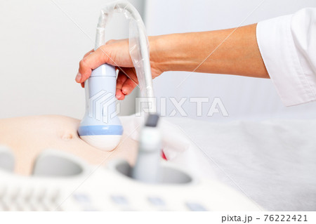 Young pregnant woman receiving obstetric ultrasonography Young pregnant woman receiving obstetric ultrasonography 76222421