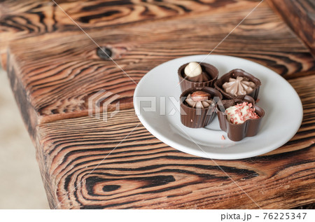 Chocolate candies on a white saucer. 76225347