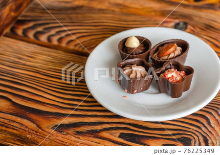 Chocolate candies on a white saucer. Chocolate candies on a white saucer. 76225349