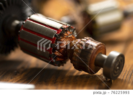Power tool repair. Details of electrical appliance and repair tools on a wooden table in a repair shop 76225993