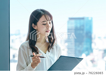 オフィスで働くカジュアル衣装の若いビジネスウーマン オフィスで働くカジュアル衣装の若いビジネスウーマン 76226065