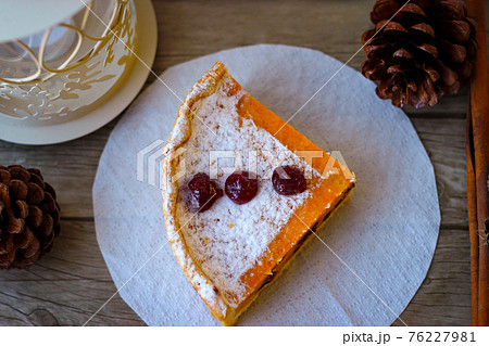 A piece of sweet pie made of cottage cheese and pumpkin, sprinkled on top with powdered sugar 76227981