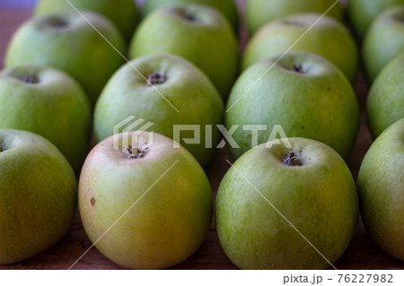 Apples stand on a wooden surface 76227982