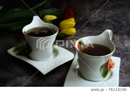 two white cups of tea and yellow and red tulips two white cups of tea and yellow and red tulips 76228190