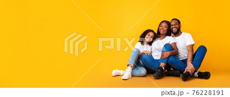 African American man, woman and girl sitting on floor 76228191