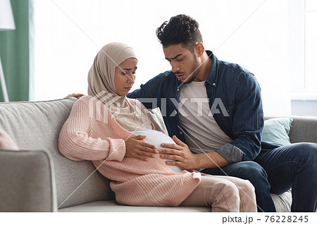 Painful Baby Movements. Pregnant Muslim Lady Suffering Abdominal Ache At Home 76228245