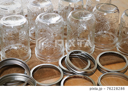Rows of pickling jars drying upsidedown on a table 76228286