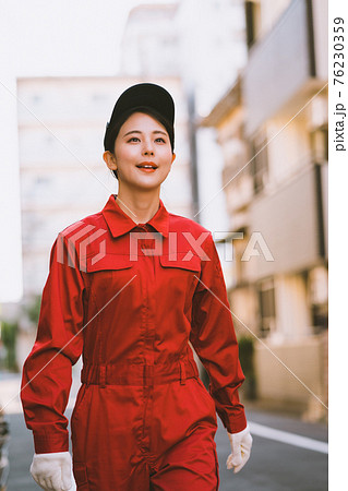 赤いつなぎを着た若い女性 76230359