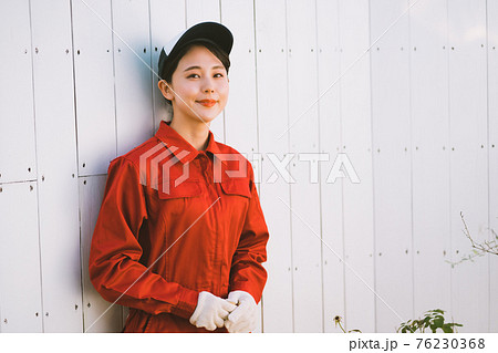 赤いつなぎを着た若い女性 76230368