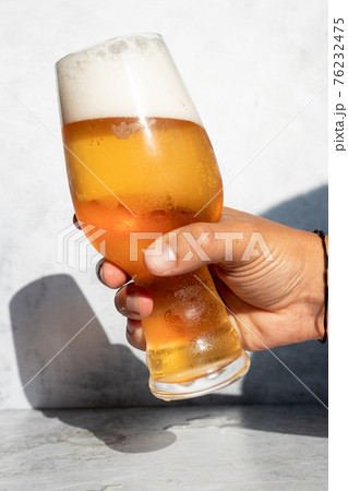 Hand holding a glass with foamy IPA beer 76232475