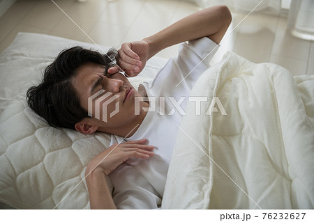 寝起きの悪い男性 寝不足の若い日本人イメージの写真素材