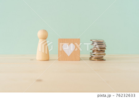 お金好き｜金の亡者｜人型の木製オブジェとハートマークの積み木と積まれたコイン（お金） 76232633