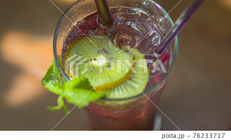Grape, Kiwi and Soda Juice in a clear glass. 76233717