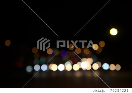 Blurry floating bokeh combination of cars on the road and street lights at the intersection, outdoor in modern big city. Beautiful blurred lights of dark night abstract. Horizontal, front view. Blurry floating bokeh combination of cars on the road and street lights at the intersection, outdoor in modern big city. Beautiful blurred lights of dark night abstract. Horizontal, front view. 76234221