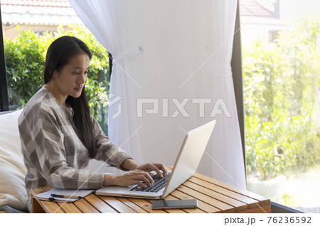 Asian woman working with laptop. Business woman busy working on laptop computer at home. Asian woman freelance online working with laptop. Business and lifestyle concept Asian woman working with laptop. Business woman busy working on laptop computer at home. Asian woman freelance online working with laptop. Business and lifestyle concept 76236592