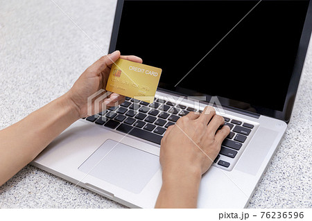 Young woman holding credit card and using laptop computer. Women working at home. Online shopping, e-commerce, internet banking, spending money, working from home concept. Technology shopping online 76236596