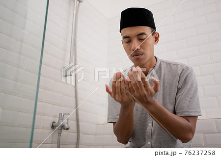 Muslim man praying after perform ablution (wudhu) at the bathroom 76237258