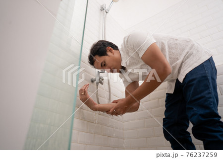 Young Muslim man perform ablution wudhu before prayer at home 76237259