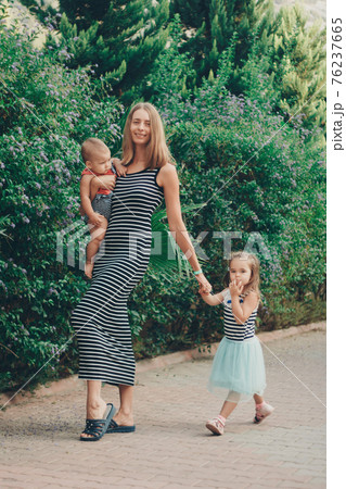 a small child sits on the mother's hands. momy's daughter is on vacation. tropical leaves. Travel to hot countries a small child sits on the mother's hands. momy's daughter is on vacation. tropical leaves. Travel to hot countries 76237665