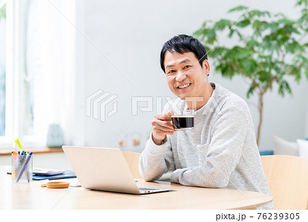 コーヒーを飲みながらテレワークするミドルのビジネスマン コーヒーを飲みながらテレワークするミドルのビジネスマン 76239305