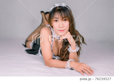 Asian woman in sexy maid dress on white bed 76239527