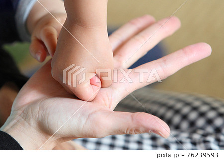 ママの手のひらにパンチをする子どもの握りこぶし 76239593
