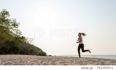 Athletic woman jogging and relax and freedom on sand beach Athletic woman jogging and relax and freedom on sand beach 76240051
