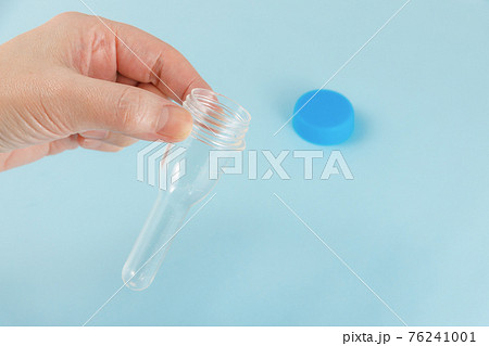 唾液用PCR検査キットを持つ女性の手 76241001