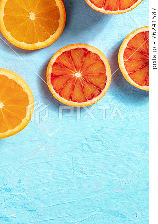 Fresh juicy oranges, shot from above on a blue background Fresh juicy oranges, shot from above on a blue background 76241587