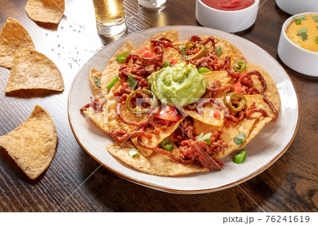 Nachos with beef on a rustic wooden table Nachos with beef on a rustic wooden table 76241619