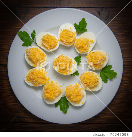 Stuffed eggs with crab crumbs, mayonnaise and parsley macro on a plate 76242098