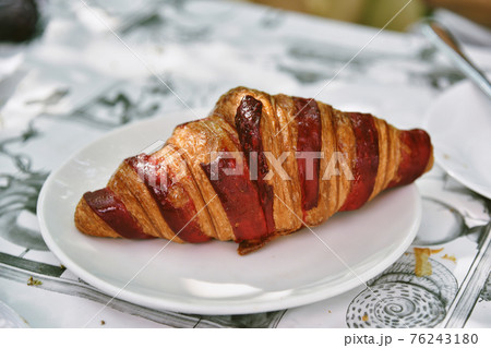 Delicious croissants and ripe berries on a white plate, French breakfast in a cafe. 76243180