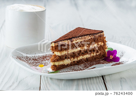 Piece of cake with coffee on white wooden table 76243400