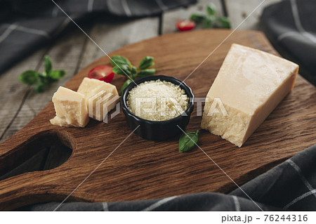 Italian cuisine concept. Parmesan Cheese chunks, cherry tomatos, basil leaves 76244316